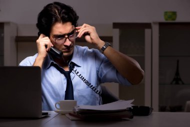 Genç yakışıklı bir çalışan ve ofiste çok fazla iş var.