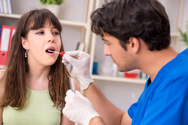 Médico recibiendo muestra de la prueba de saliva en el hospital clínico — Foto de Stock