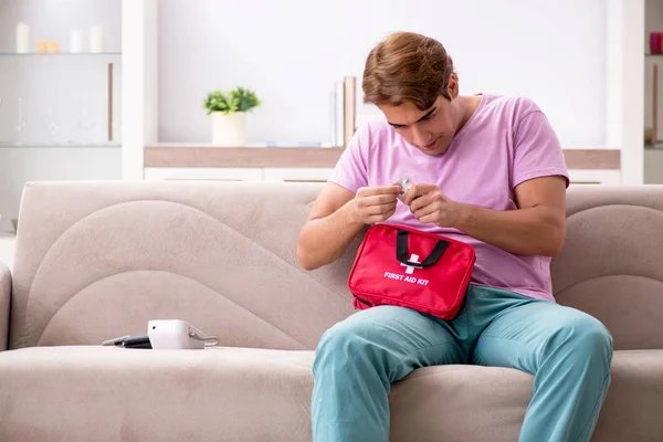 Homem doente em casa com kit de primeiros socorros — Fotografia de Stock