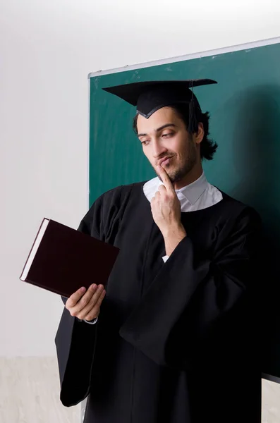 Estudante graduado na frente do quadro verde — Fotografia de Stock