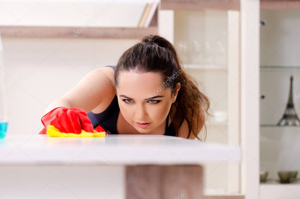 Young beautiful woman cleaning apartment