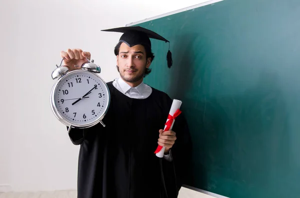 Estudante graduado na frente do quadro verde — Fotografia de Stock