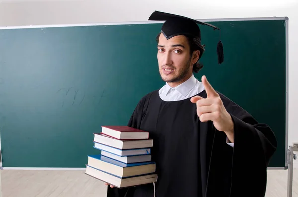 Estudante graduado na frente do quadro verde — Fotografia de Stock