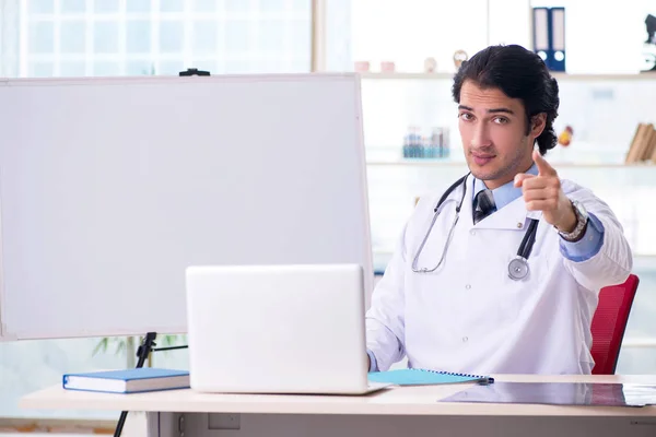 Jeune beau médecin devant le tableau blanc — Photo