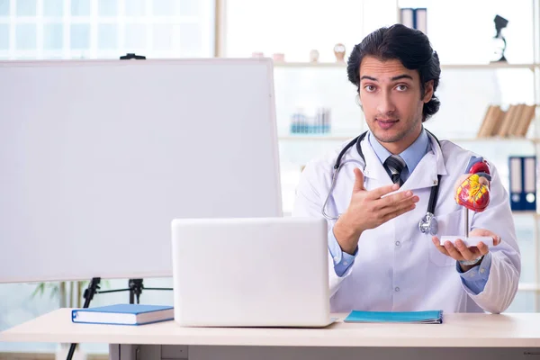 Jeune beau médecin cardiologue devant tableau blanc — Photo