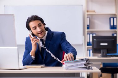 Genç yakışıklı işadamı ofiste çalışıyor.