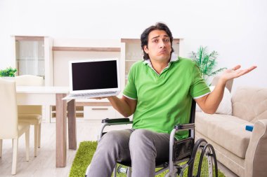 Tekerlekli sandalyedeki genç yakışıklı adam.