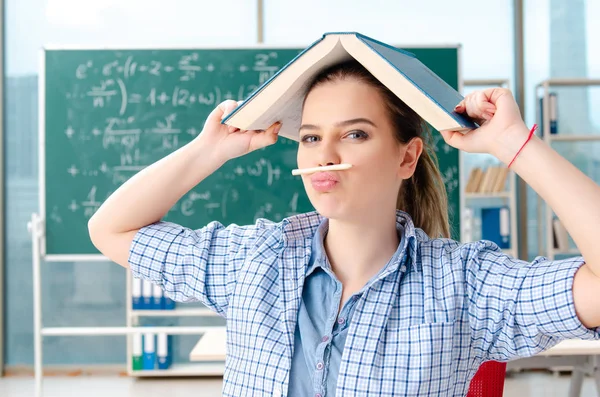 Studentessa con molti libri seduti in classe — Foto Stock