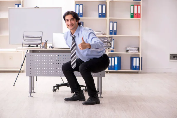 Junge hübsche männliche Angestellte machen Übungen im Büro — Stockfoto