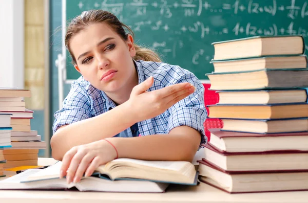 Estudante com muitos livros sentados em sala de aula — Fotografia de Stock