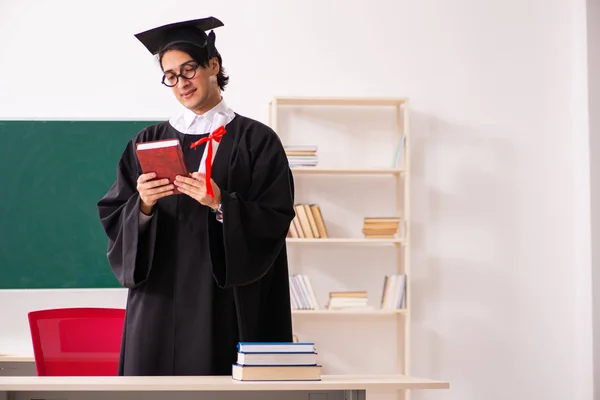 Estudante graduado na frente do quadro verde — Fotografia de Stock