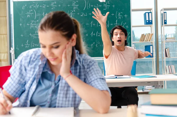 Jovens estudantes fazendo o exame de matemática em sala de aula — Fotografia de Stock