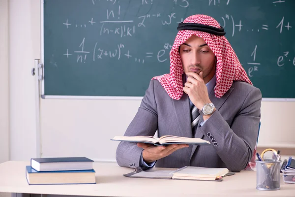 Arab teacher wearing suit in front of chalkboard — Stock Photo, Image