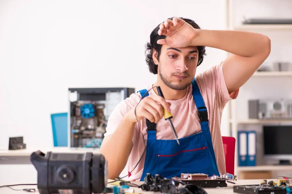 コンピュータを修理する若い男性請負業者 — ストック写真