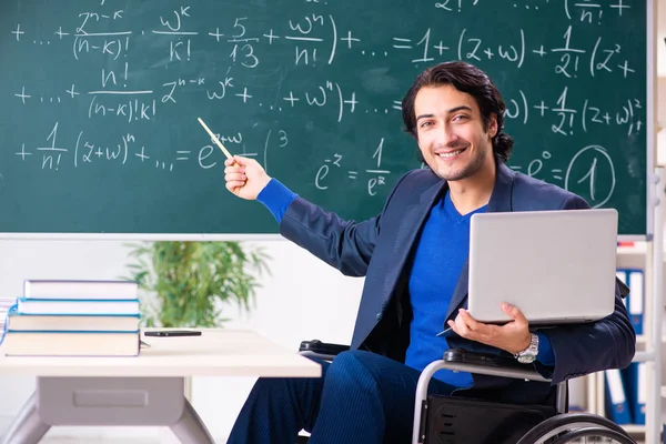 Jonge knappe man in rolstoel voorkant schoolbord — Stockfoto