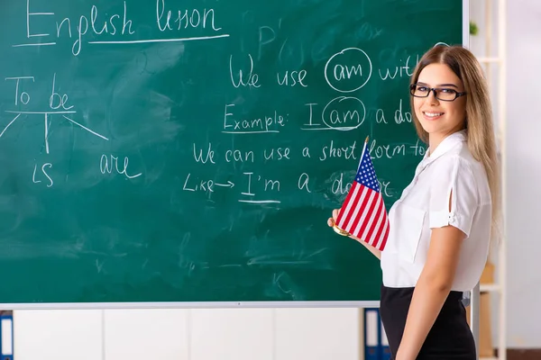 Jovem professora de inglês do sexo feminino em pé na frente do b — Fotografia de Stock