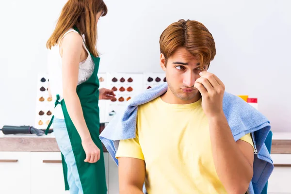 Cabeleireiro mulher aplicando tintura para o cabelo do homem — Fotografia de Stock