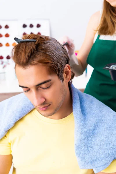 Woman hairdresser applying dye to man hair — Stock Photo, Image