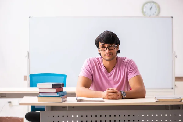 Mladý muž student sedí ve třídě — Stock fotografie