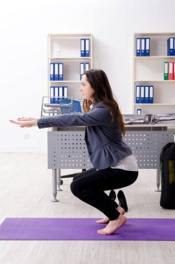 Kadın işçilerin ofiste spor egzersizleri yapıyor 