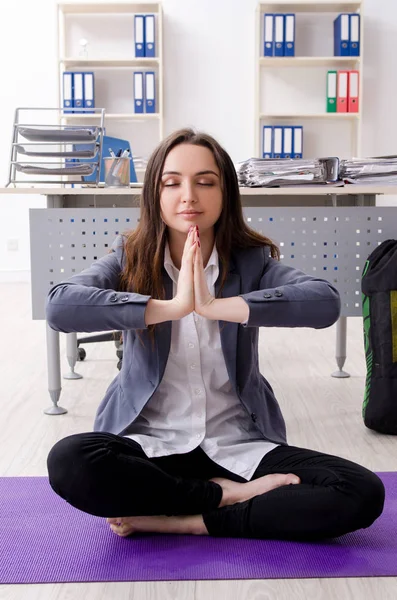 Female employee doing sport exercises in the office — Stock Photo, Image