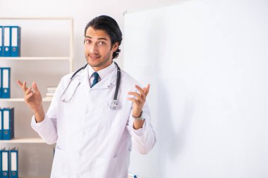 Genç doktor beyaz tahtanın önünde. 