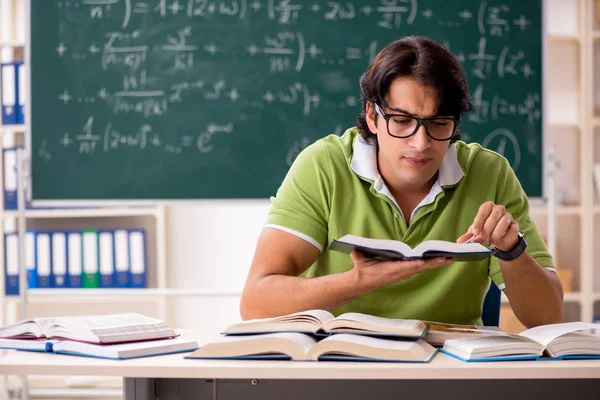 Estudiante guapo delante de pizarra con fórmulas — Foto de Stock