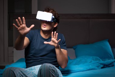 Genç adam, gece yatakta ile bilgisayar oyunu oynamak