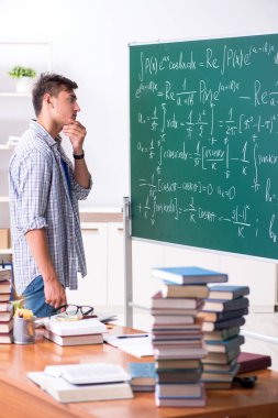 Genç erkek öğrenci okulda matematik