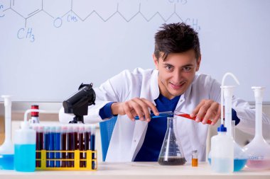 Laboratuarda oturan genç kimyager 