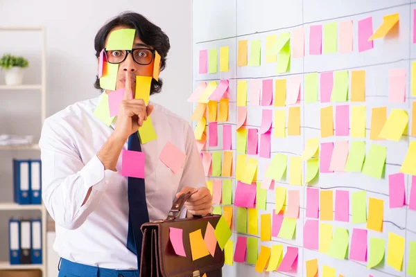 Junger Mitarbeiter in widersprüchlichem Prioritätenkonzept — Stockfoto