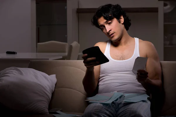 Young man calculating expences night at home — Stock Photo, Image