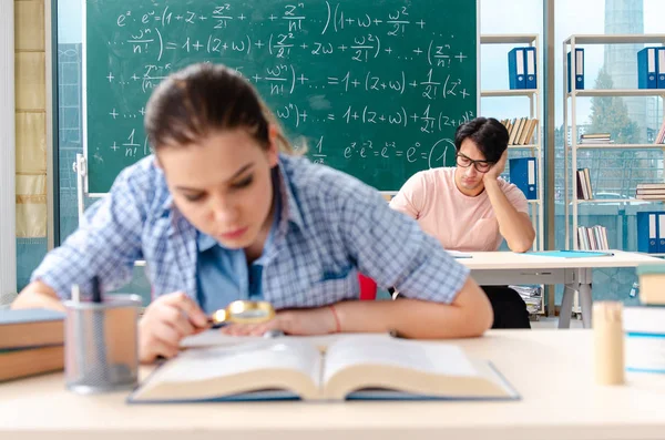 Jóvenes estudiantes tomando el examen de matemáticas en el aula — Foto de Stock