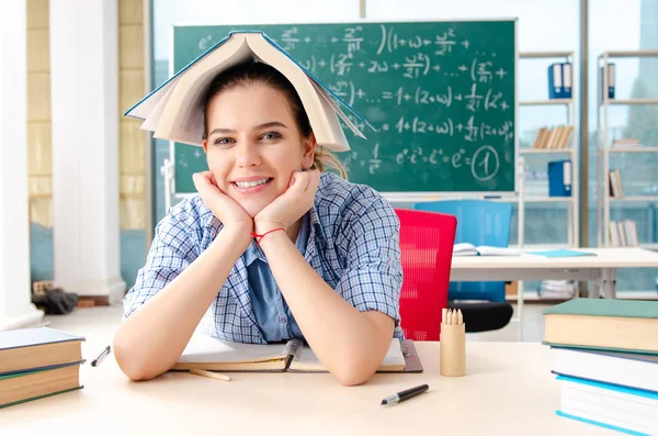 Female student with many books sitting in the classroom — Stock Photo, Image