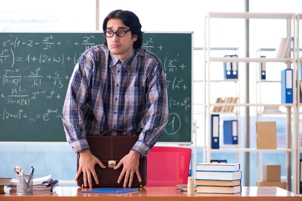 Young funny math teacher in front of chalkboard
