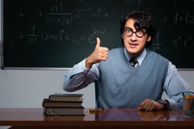 Kara tahta önünde genç matematik öğretmeni