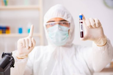 Genç yakışıklı laboratuvar asistanı hastanede kan örnekleri test ediyor. 