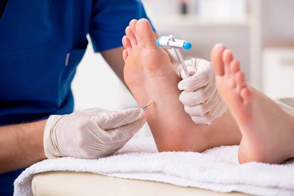 Podólogo tratando los pies durante el procedimiento — Foto de Stock