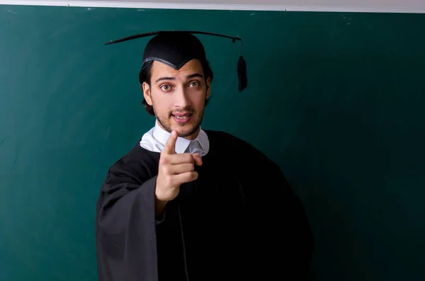 Graduate student in front of green board — Stock Photo, Image