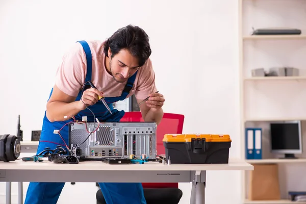 Jovem empreiteiro do sexo masculino reparando computador — Fotografia de Stock