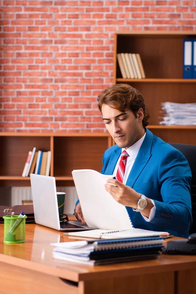 Joven empleado guapo sentado en la oficina —  Fotos de Stock