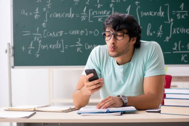 Kara tahta önünde genç erkek öğrenci matematikçi 