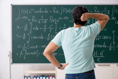 Kara tahta önünde genç erkek öğrenci matematikçi 