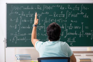 Kara tahta önünde genç erkek öğrenci matematikçi 