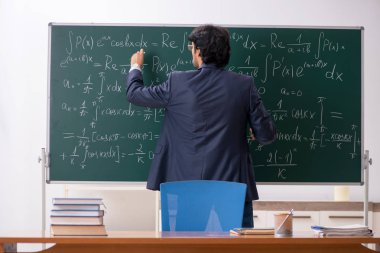 Genç erkek matematik öğretmeni sınıfta 