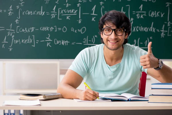 Mladý muž student matematik před tabuli — Stock fotografie