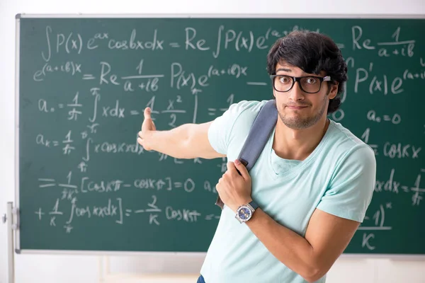 Unge mandlige studerende matematiker foran tavle - Stock-foto