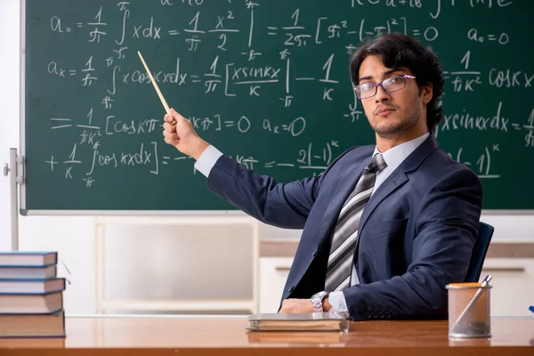 Young male math teacher in classroom