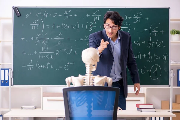 Joven profesor de matemáticas masculino y esqueleto de estudiante —  Fotos de Stock