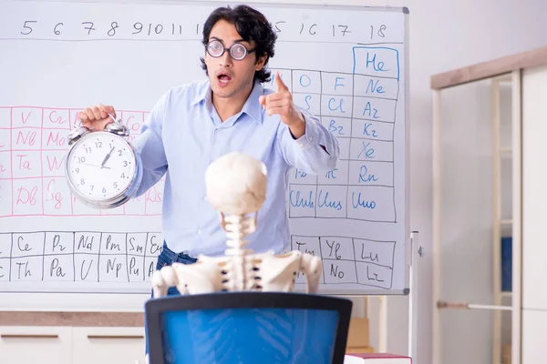 Jonge mannelijke scheikundige onderwijzer en student skelet — Stockfoto